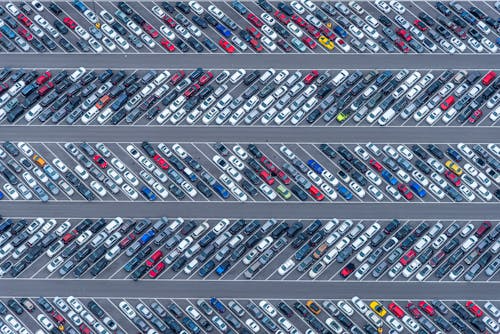 Parking lot experiencing heavy vehicle movement and congestion.