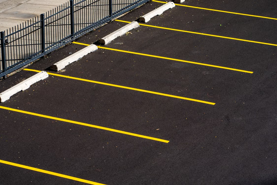 An aerial view of an empty parking lot with clearly marked yellow lines