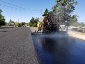 Fresh asphalt being laid on a road during sunny weather